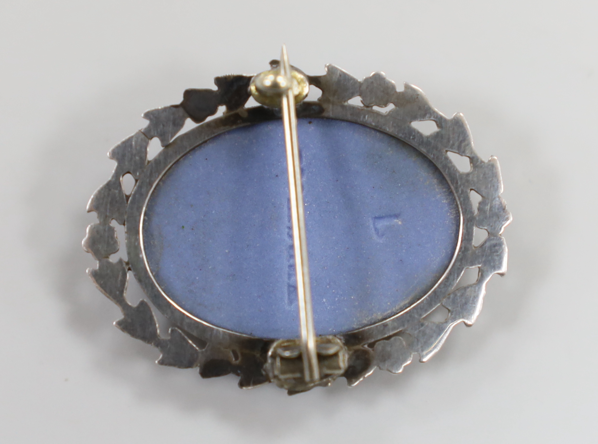 A white metal mounted Wedgwood blue jasper oval brooch, decorated with the figure of a maiden, 32mm.